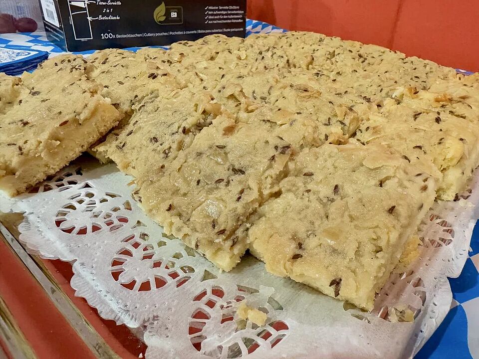 Zwiebelkuchen Oktoberfest-Buffet Angerichtete Stücke Zwiebelkuchen auf bayrisch karierter Tischdecke beim Oktoberfest-Buffet